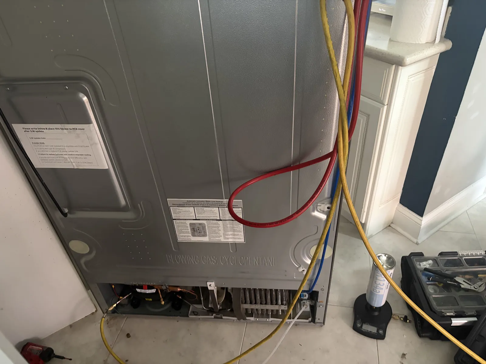 Rear compressor compartment of an LG refrigerator opened for compressor replacement in Deerfield Beach Florida