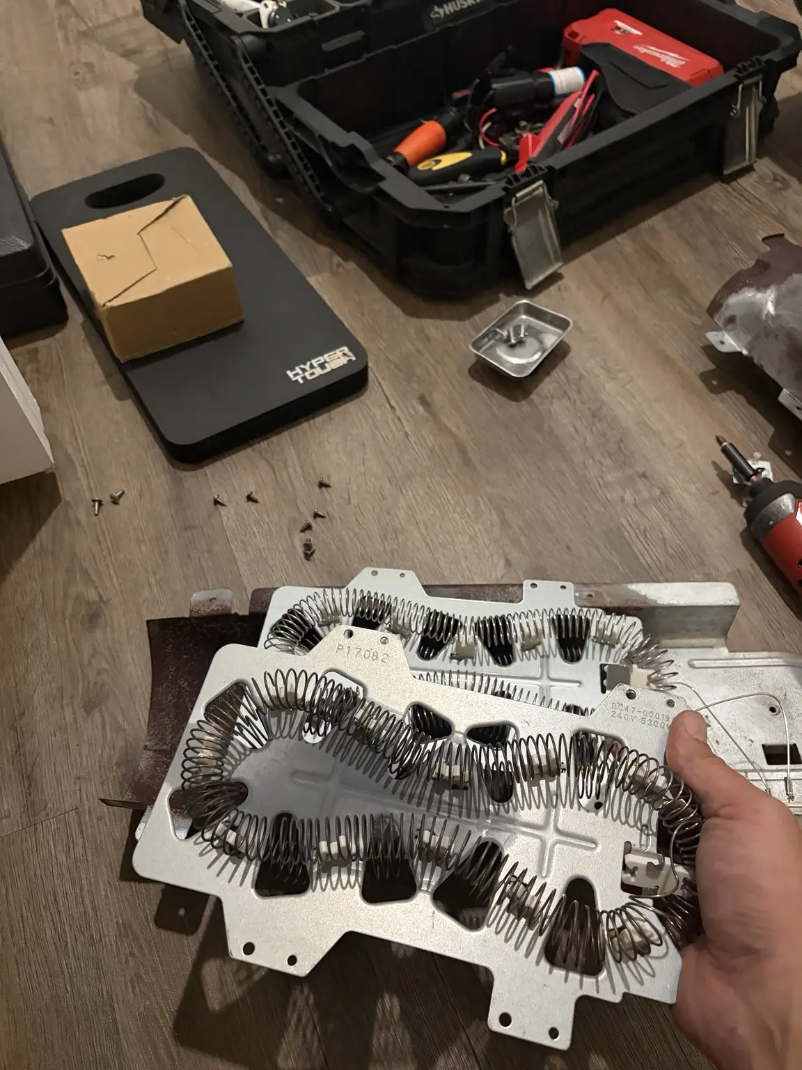 Old and replacement Samsung dryer heating elements compared during repair